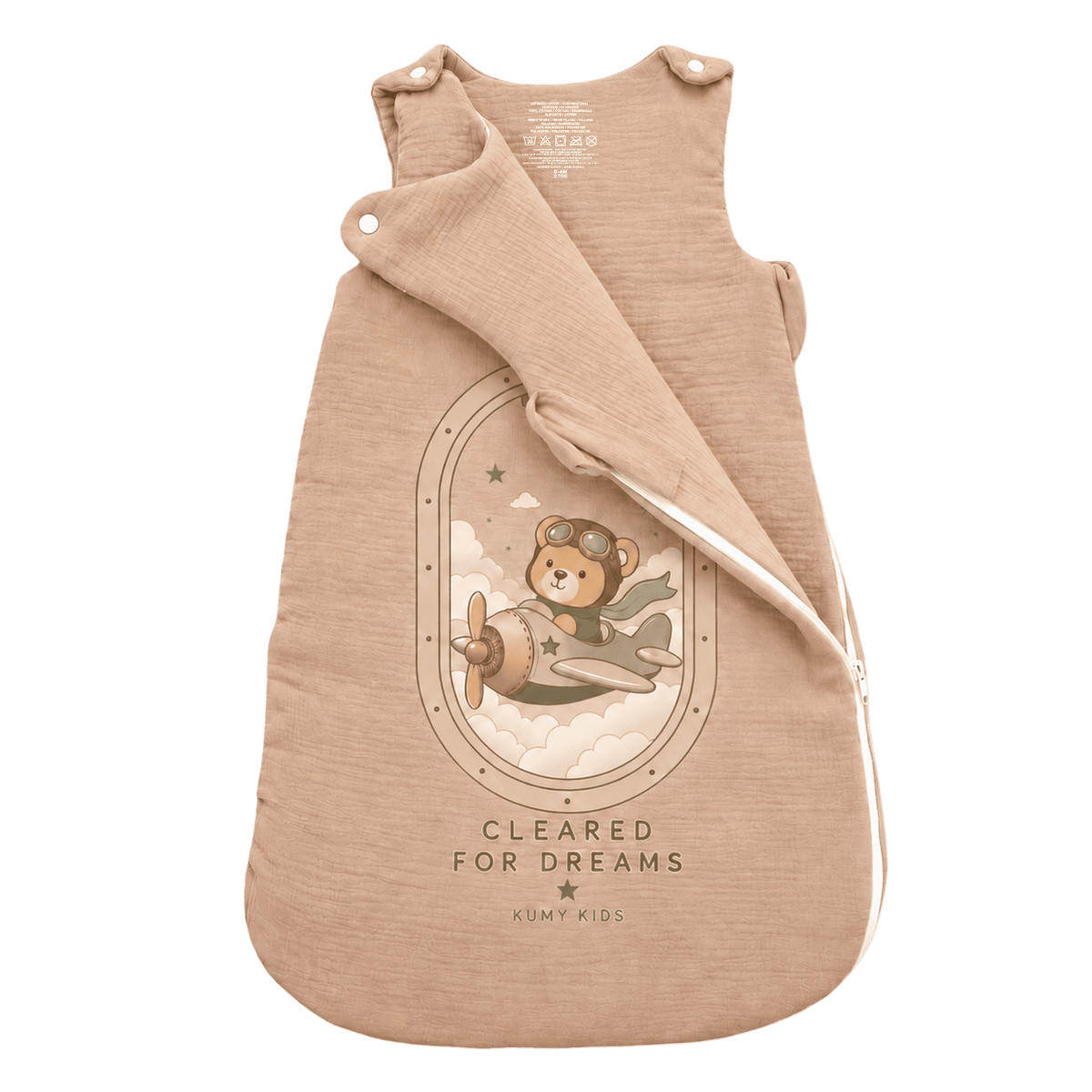 A beige baby sleeping bag with a printed graphic of a teddy bear in a vintage airplane, featuring the text 'CLEARED FOR DREAMS' and the brand 'KUMPY KIDS'.