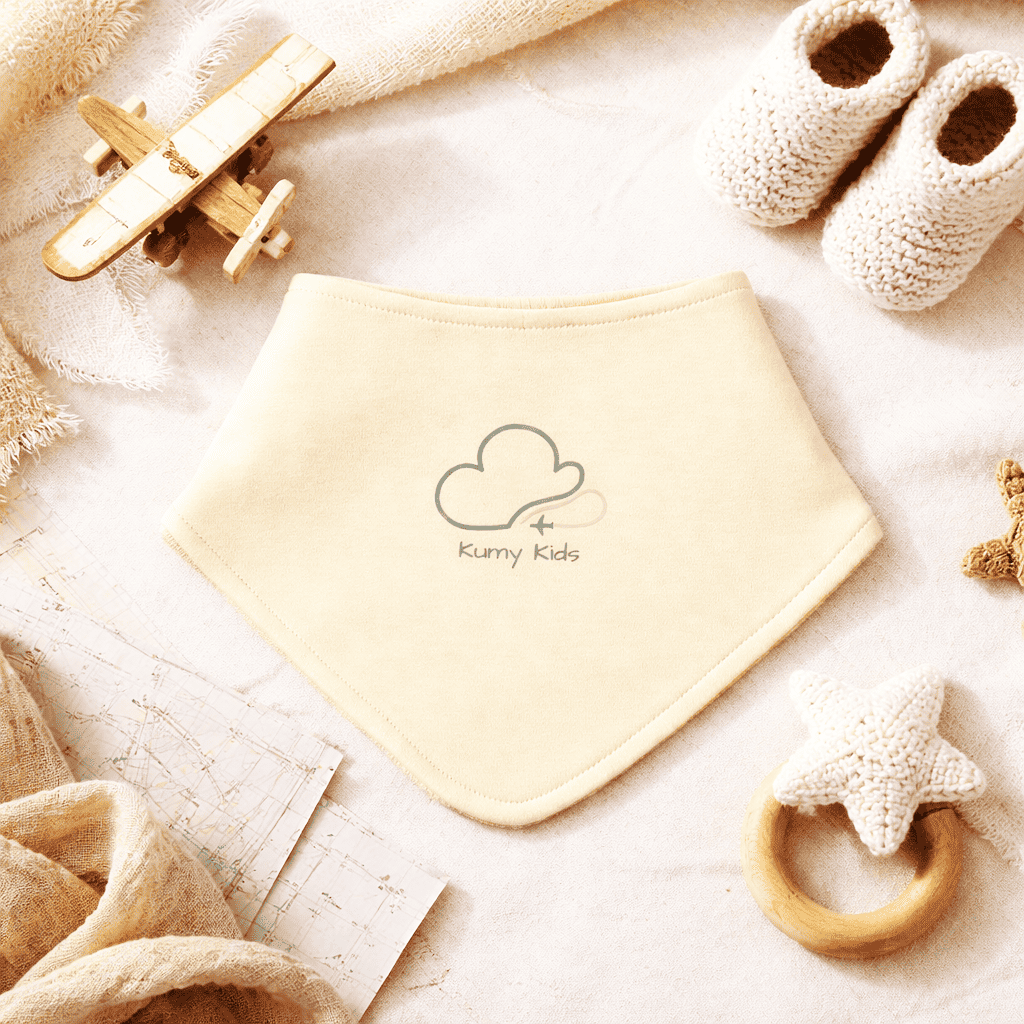 Beige baby bib in soft newborn lifestyle setting with premium gift styling